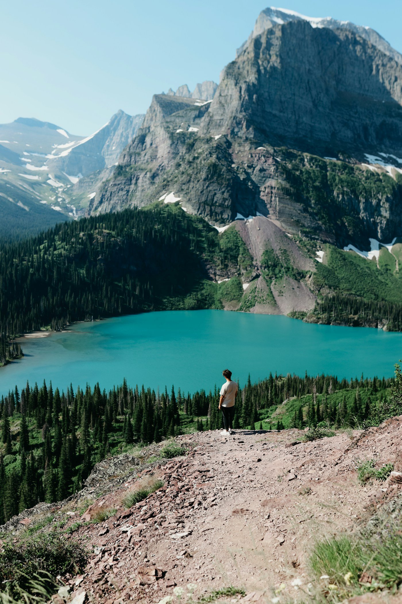 A traveler looking across a mountain lake